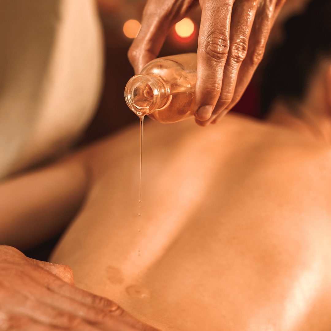Ayurvedic oil massage — warm oil poured along the client's back