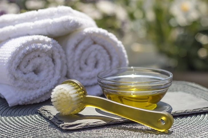 Golden oil and fresh towels prepared for a honey massage session